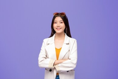portrait of young pretty smiling asian woman in smart casual clothes aside on colorful purple background