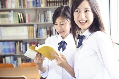 japanese high-school students opening the book in the library