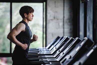 handsome asian men are exercising in sportswear and jogging on the treadmill at the gym. electric treadmill in the fitness center