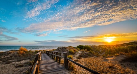 photo taken in punta umbria, huelva, spain. it is a plank path that leads to the beach, in a magical sunset.