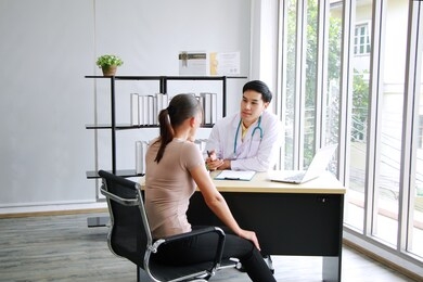 asian psychiatrist (md) man is counseling and encouraging for caucasian woman have mental health problems in clinical depression life. major depressive disorder patients and healthcare concept.