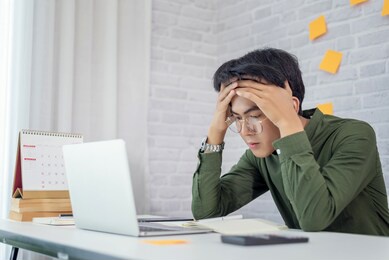 feeling tired. young asian businessman feeling stress from work.