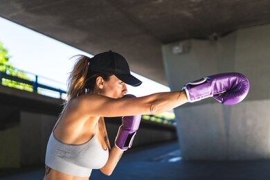 spanish woman training boxing with coach outdoors. beautiful woman boxing with personal trainer. personal trainer boxing. sport concept.