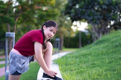 pre teen asian girl exercising outdoors at sunset