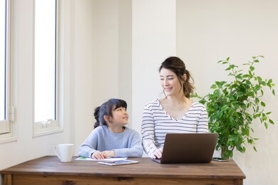 a pregnant woman working at home and a child watching
