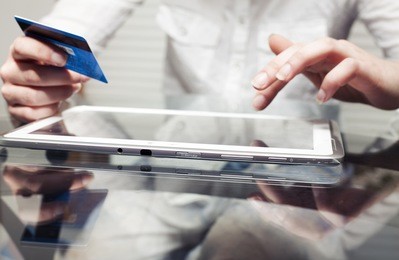 woman holding tablet pc and credit card indoor, shopping online
