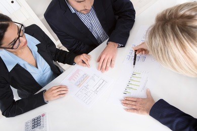 young couple has consultation with consultant at desk at office.