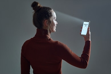 woman scans face using facial recognition system on smartphone for biometric identification. future high tech technology and face id