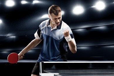 sports man celebrates victory on the dark background with lights