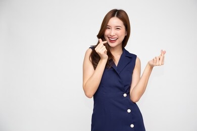 young asian woman showing mini heart sign isolated on white background, speading love and happiness concept