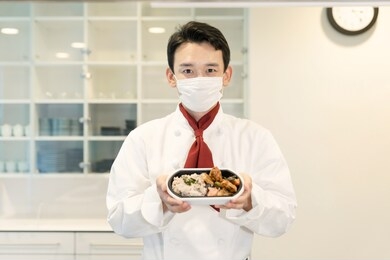 asian cook in showing lunch box the kitchen. restaurant. lunch vendor.