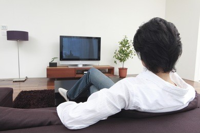 rear view of a japanese man watching tv in the living room
