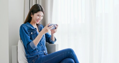 asian woman play game with smart phone and exciting
