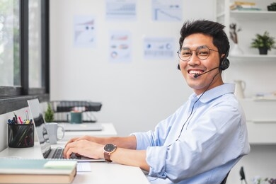 young asian businessman work at office and virtual video conference meeting with colleagues business people, online working, video call social distancing and new normal concept
