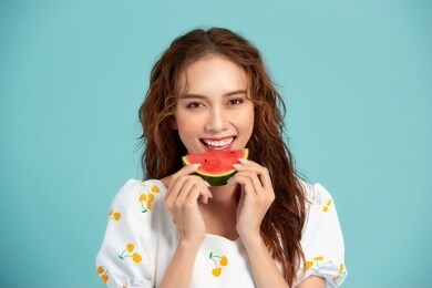 portrait happy young asian woman is holding slice of watermelon, funny and happiness concept