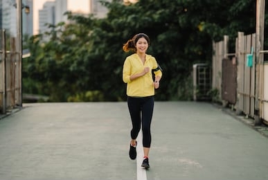 beautiful young asia athlete lady running exercises work out in urban environment. japanese teen girl wearing sports clothes on walkway bridge in early morning. lifestyle active sporty in city.