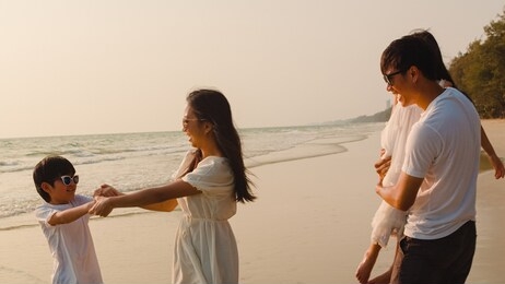 asian young happy family enjoy vacation on beach in the evening. dad, mom and kid relax playing together near sea when sunset while travel holiday. lifestyle travel holiday vacation summer concept.