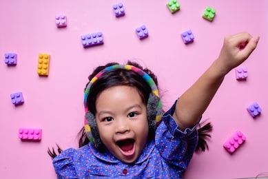 girl happy colorful toy pink background 