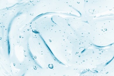 hand sanitizer gel background. clear colored cream with bubbles texture. skincare hygiene product closeup