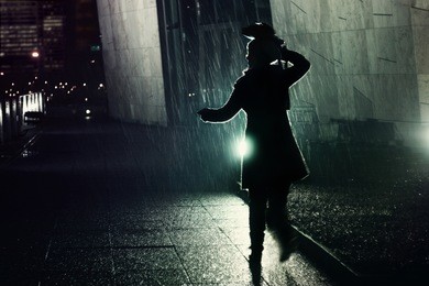 young woman running away from the rain at night, protecting her head with her bag