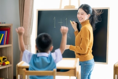 asian woman teacher and her smart student in class room with backboard background, this image can use for preschool, genius, clever, study, education and school concept.