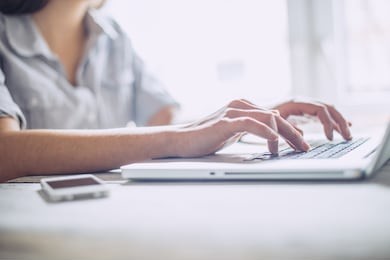 closeup of a female hands busy typing on a laptop