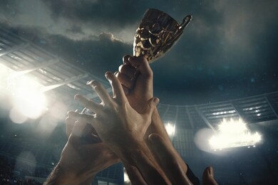 hard work. award of victory, male hands tightening the golden cup of winners against cloudy dark sky. sport, competition, championship, winning, achieving the goal. prize for success and honor.