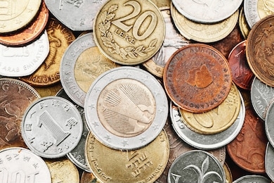 different currency coins stacked. pile of money. metal coins texture. financial world background. german one euro eagle, twenty albanian leke coin.