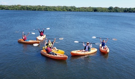 young family having fun kayaking with teenagers in south florida