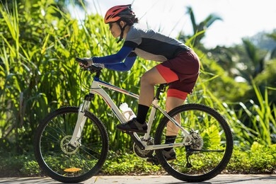 woman riding bike down a slope on sunny day