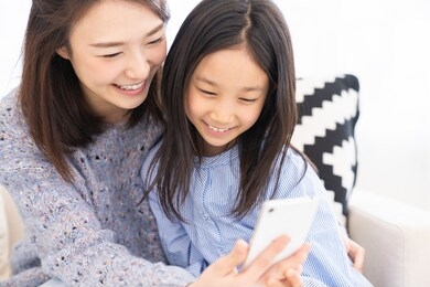young asian mother and daughter,smart phone