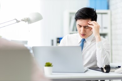 asian young businessman has headache and feel upset in office