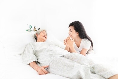old asian patient sick and admit in hospital, young asian female visiting old female, they holding hands together,  they feeling happy and smile, elderly healthcare