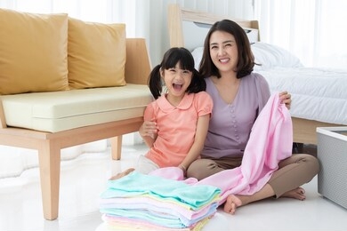 asian mom and daughter doing laundry at home
