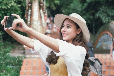 asian woman use smart phone to take selfie photo. traveler tourist travel on holiday vacation. journey trip concept