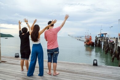 back view of three asian friends group having fun together on the beach