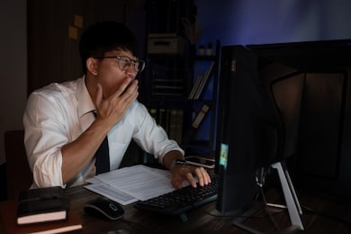 businessman workaholic sit at the computer working late at night yawn tired and sleeping in the office,hard work in the later time concept