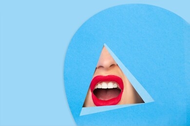 scream. close up female red lips peeks throught triangle in blue background. trendy geometrical style, copyspace. vibrant colors. hidden emotion, make up. sales, proposal, finance and business concept
