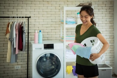 young woman doing laundry at home.
