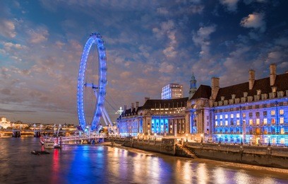 the london eye at sunset. panoramic wheel with thames reflections.