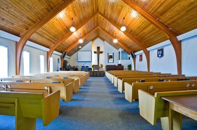 the interior of a simple church with a vaulted wooden ceiling and beams