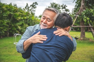father and son show love by hugging in outdoors, asian family