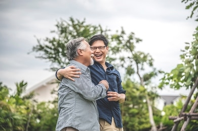 father and son, embracing and talking happily, asian family