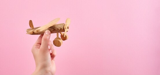 travel insurance airplane protection. wooden airplane model and female hands. concept of airline safety, security and insurance.