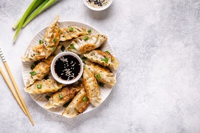 fried dumplings gyoza with soy sauce, and chopsticks, top view.