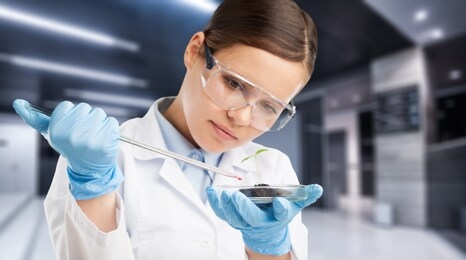 laboratory researcher holding medical glass bottle with pipette wearing sterile gloves