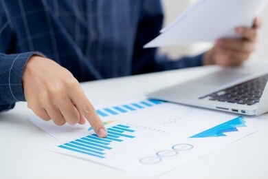 hand of young business man pointing document data graph and chart paper, marketing and investment, report of statistics profit for financial, economic and growth of finance, management and planning.