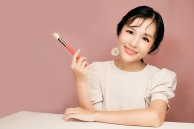 asian girl beauty blogger with makeup brush 