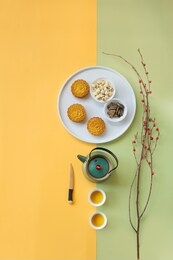 flat lay mid autumn festival snack and drink, moon cake and tea set on decorative coloured background still life image. 