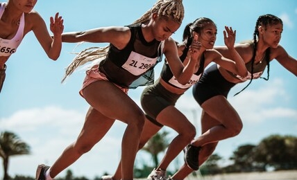 athletes starting off for a race on a running track. female runner starting a sprint at stadium track.